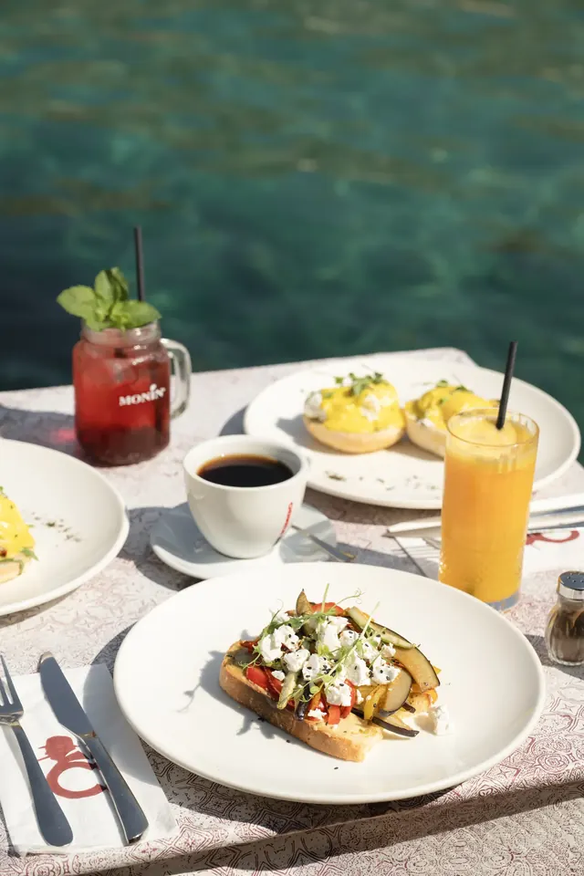 Bruschetta, eggs Benedict and drinks beside the bay